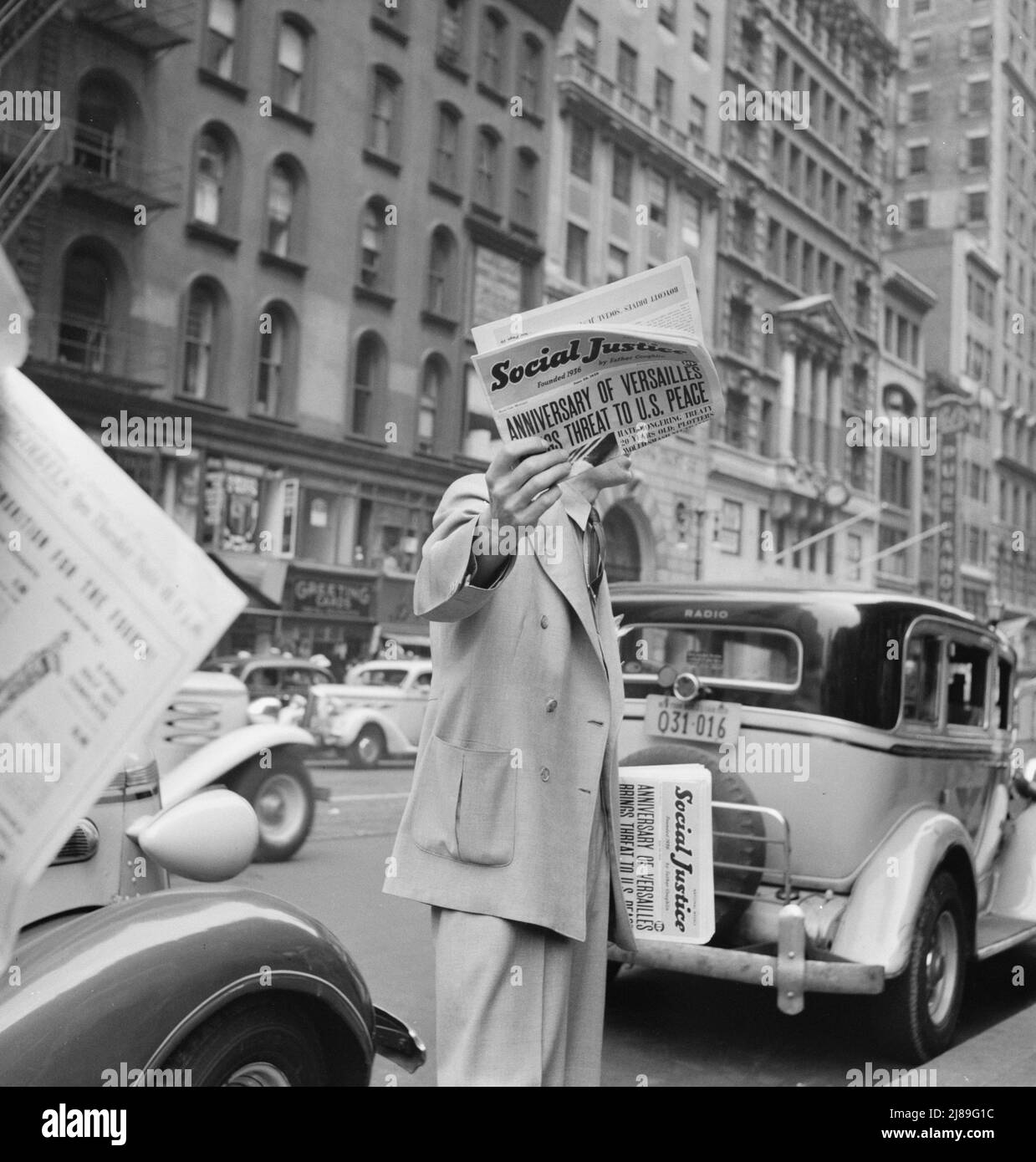 La justice sociale, fondée par le Père Coughlin, est vendue dans les coins et les intersections importants de la rue. New York. [Titre: «L'anniversaire de Versailles menace la paix des États-Unis»]. Banque D'Images