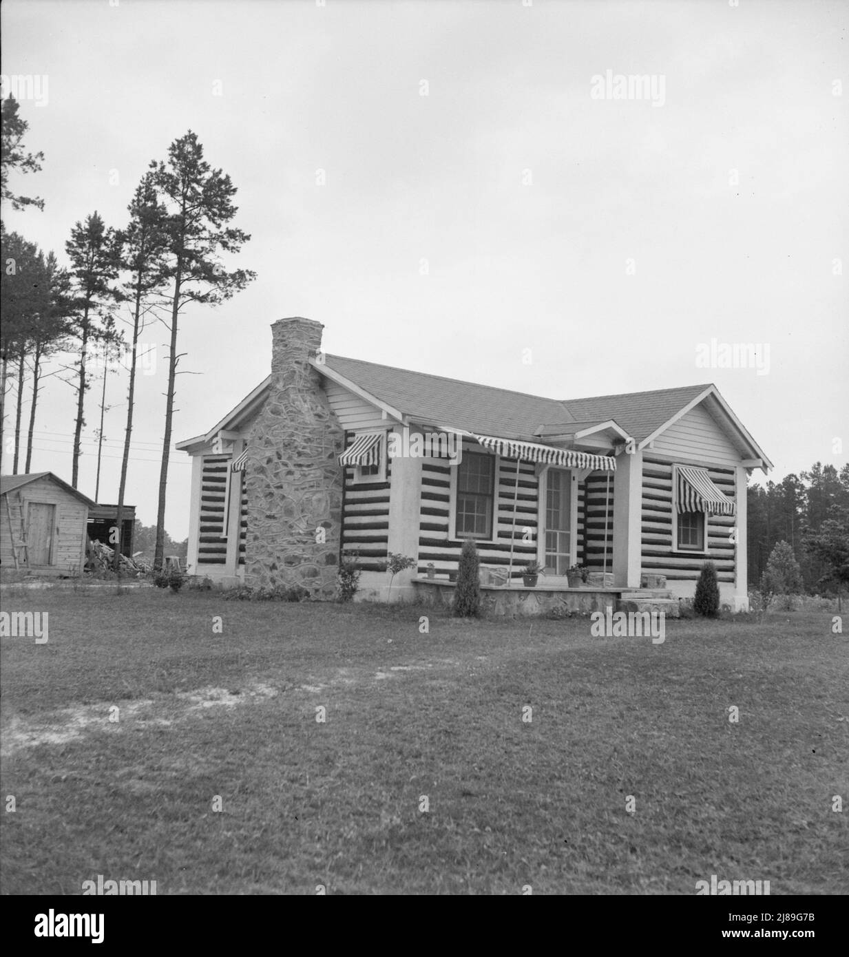 Note sur l'architecture. Un nouveau bungalow en bois très chic montrant l'influence de la construction de la grange de tabac. Les grumes sont peintes en noir et blanc. Près de Gordonton, Caroline du Nord. Banque D'Images