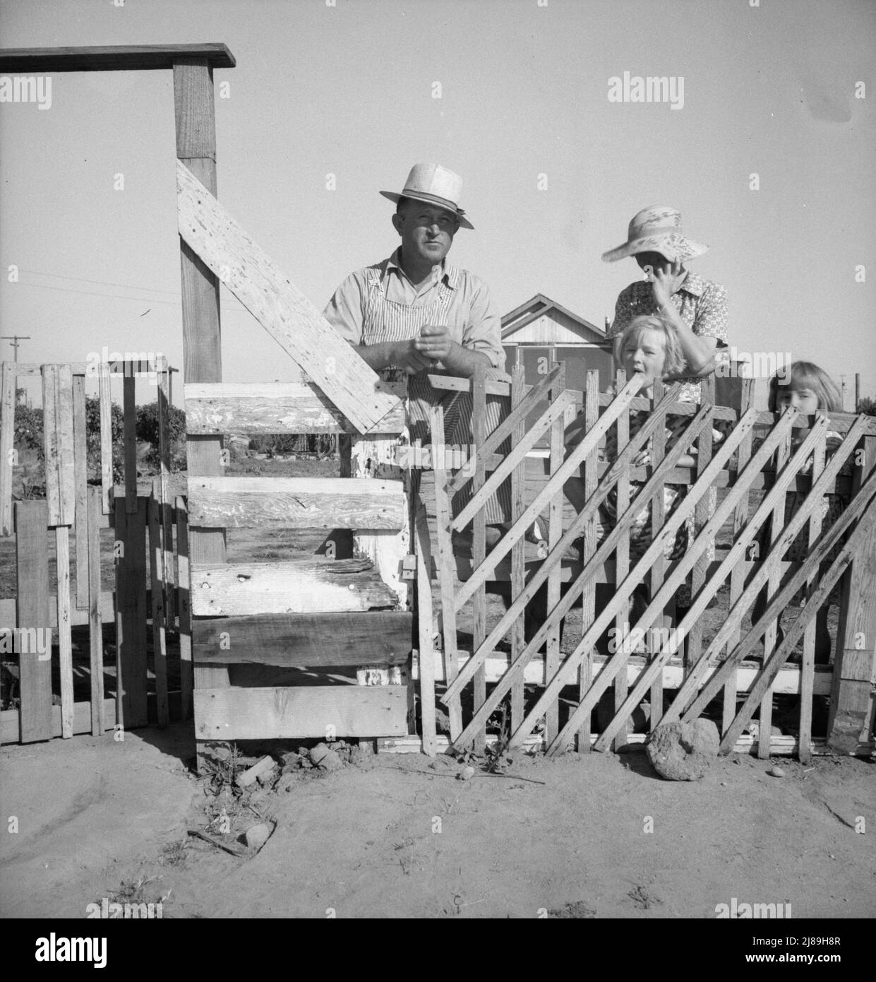 Highway City, Californie, près de Fresno. Famille de l'Oklahoma; ont été en Californie pendant six ans, ont été les travailleurs migrants maintenant dans travaux Progress Administration (WPA) d'où ils peuvent être coupés à l'ouverture de la récolte 1939. Leur maison représente l'une des nombreuses structures similaires, qu'ils tentent de construire par leurs propres efforts sur les terres pauvres, pour lesquelles ils paient quelques dollars par mois du budget de la WPA. Leur facture de lumière est de deux dollars par mois. Facture d'eau un dollar par mois, kérosène pour cuisiner cinq dollars par mois, environ. Ils possèdent une Ford 1929. « Th Banque D'Images