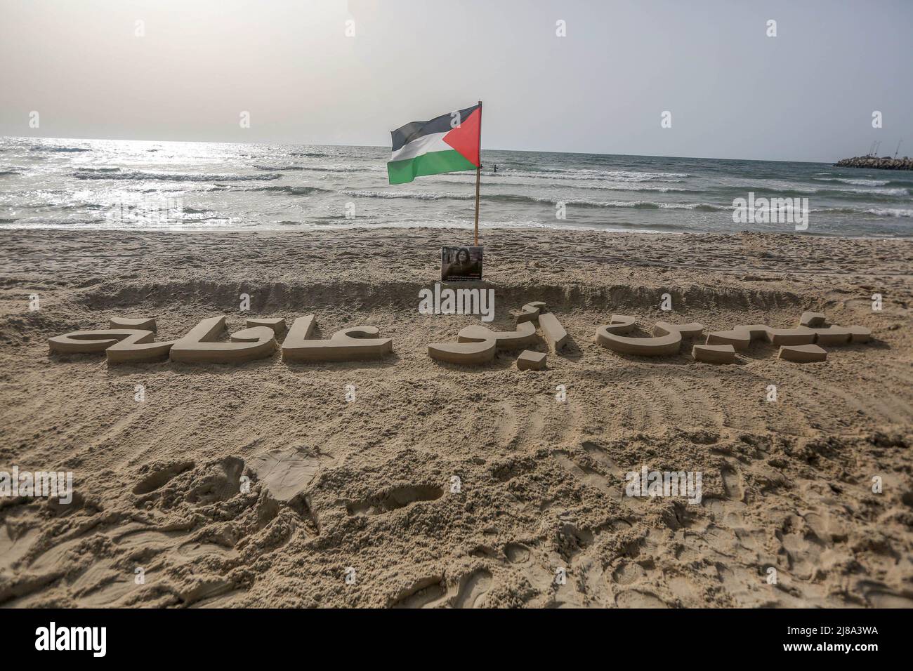 Le nom du journaliste palestinien assassiné Shireen Abu Oqla, gravé dans le sable sur les rives de la mer Méditerranée à Gaza comme un hommage. Le journaliste d'Al-Jazeera Shireen Abu Oqla (51 ans), a été tué par balle le 11 mai 2022 à l'aube tout en couvrant la tempête du camp de réfugiés de Djénine en Cisjordanie. Banque D'Images