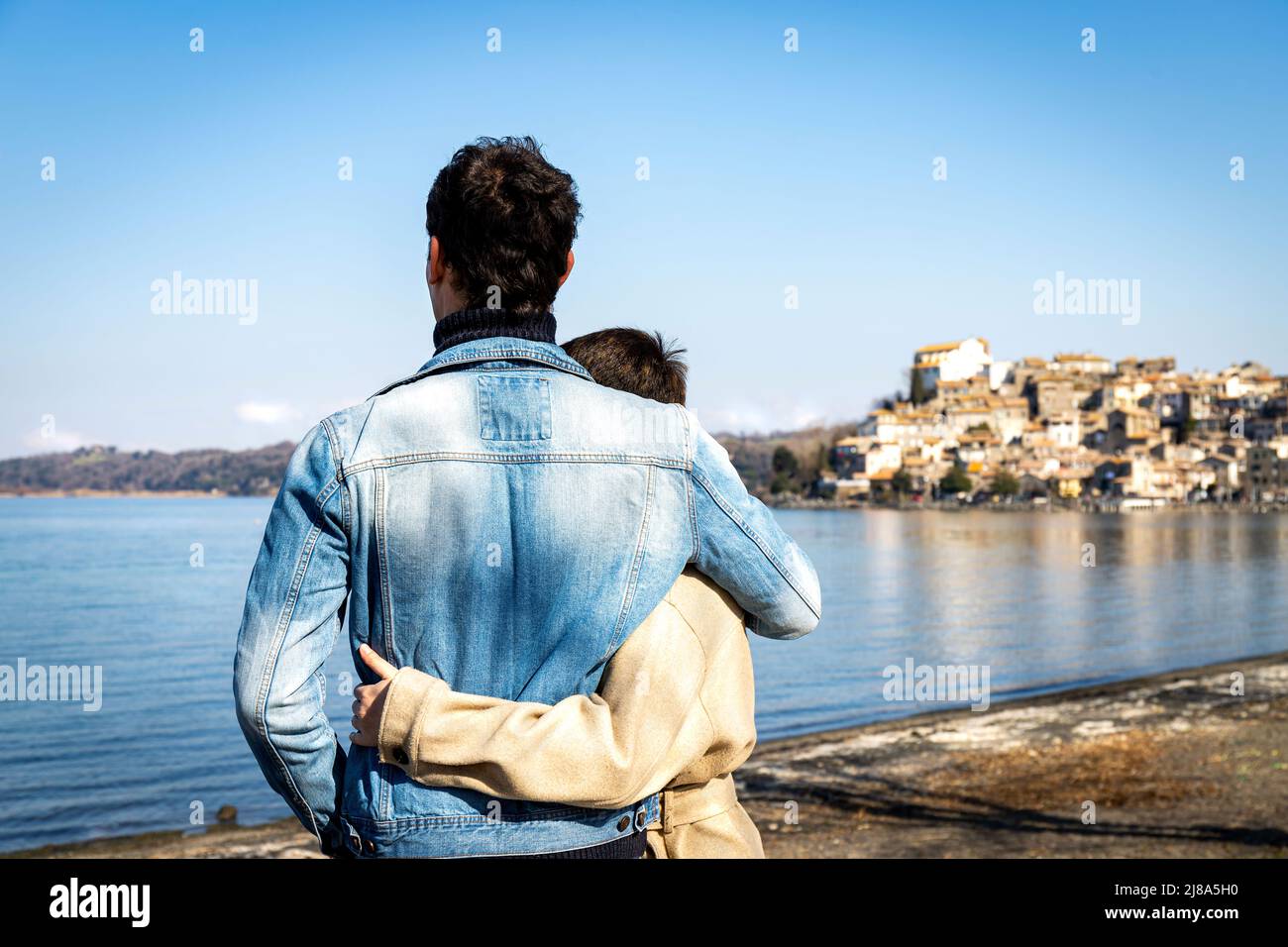 Un jeune couple embrasse sur la rive du lac Bracciano. Beau couple voyageant à Anguillara Sabazia en Latium, Italie. Atmosphère romantique et copie s Banque D'Images