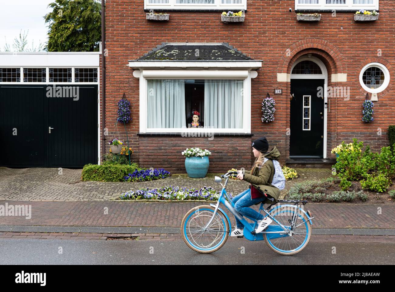 Echt, Limbourg, pays-Bas, 04 07 2022 - écolière sur un vélo passant par une  maison régulière en pierre de brique Photo Stock - Alamy