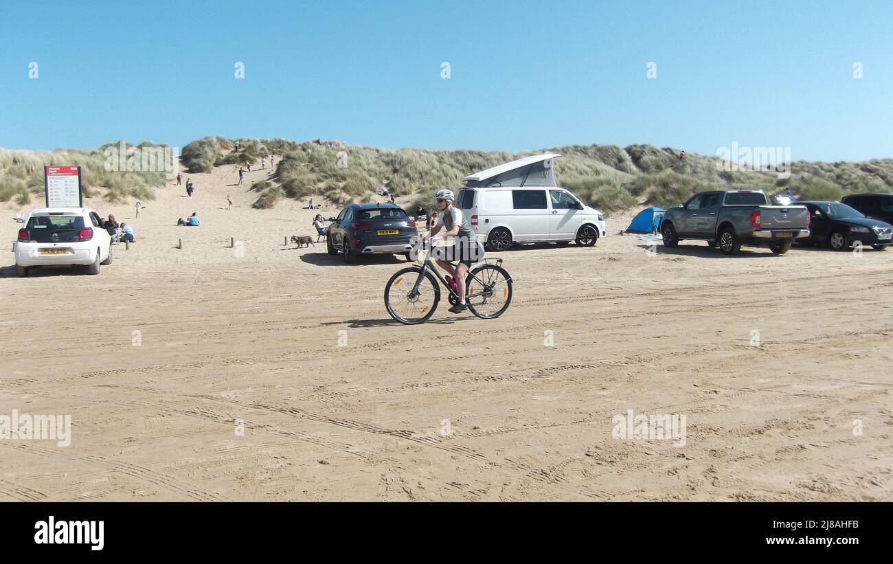 Cycliste sur la plage d'Ainsdale avec ciel bleu vif et espace de copie, Ainsdale UK Banque D'Images