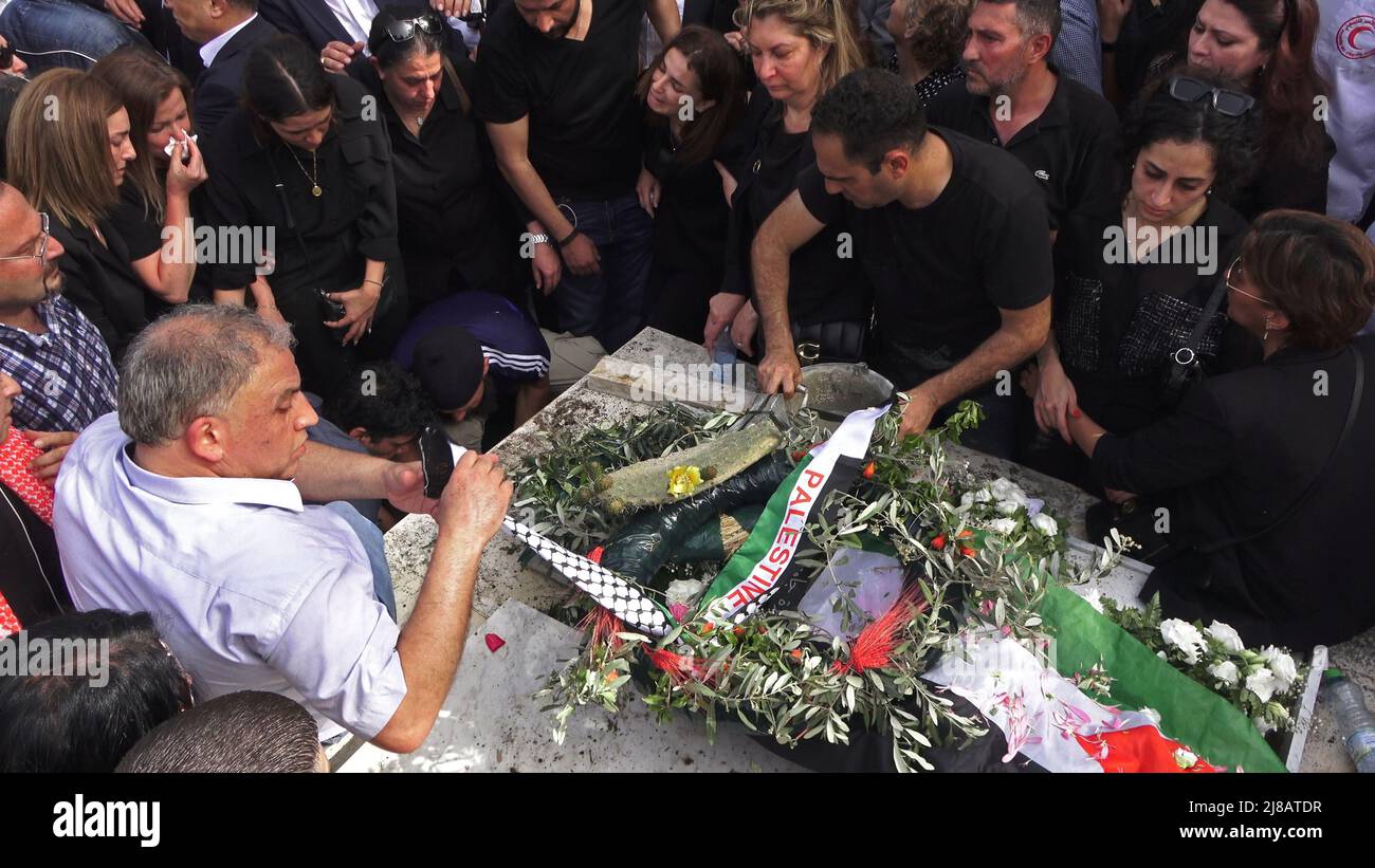 JÉRUSALEM, ISRAËL - 13 mai: Des membres de la famille pleurent lors de l'enterrement du journaliste d'Al-Jazeera Shireen Abu Akleh pleurent dans un cimetière chrétien de la montagne Sion, sur 13 mai 2022, à Jérusalem, en Israël. La journaliste palestinienne américaine Shireen Abu Akleh a été tuée par balle alors qu'elle couvrait un raid militaire israélien dans la ville de Jénine, en Cisjordanie. Banque D'Images