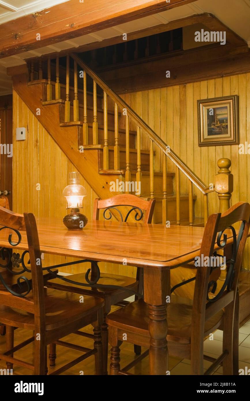 Table ancienne avec chaises, escalier dans la salle à manger à l'intérieur de la vieille maison de style Canadiana datant de 1850. Banque D'Images