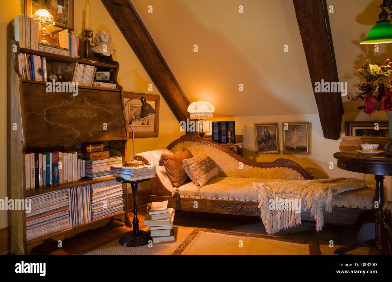 Salle de lecture avec lit de repos et beaucoup de livres à l'intérieur de la maison en rondins de style Cottage datant de 1800s reconstruite. Banque D'Images