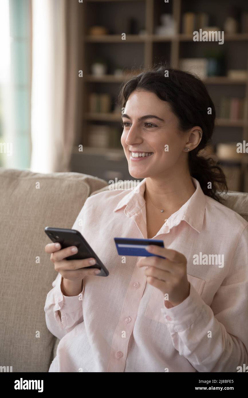 Vue verticale femme souriante Profitez du shopping électronique à la maison Banque D'Images