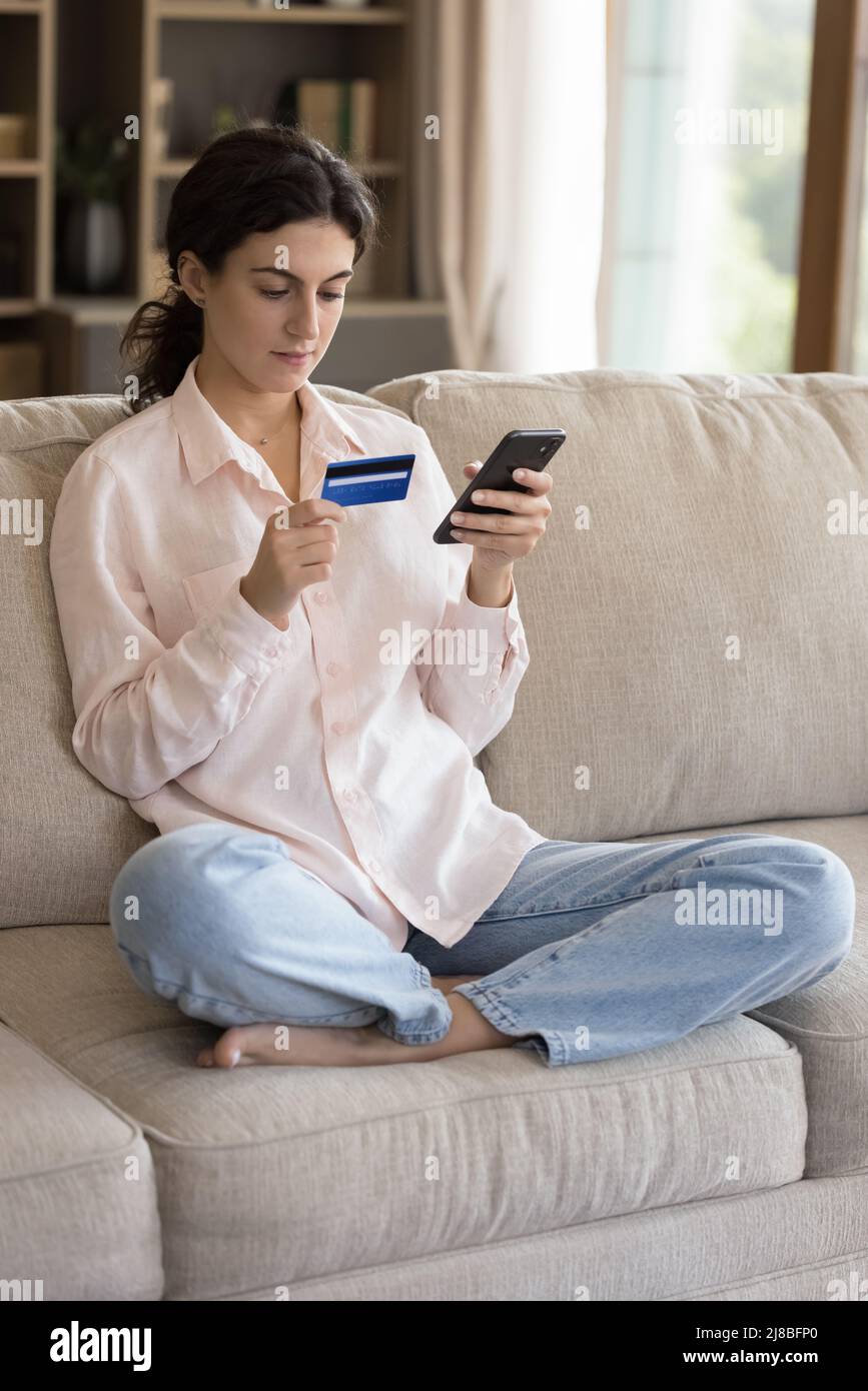 Jeune femme acheter sur Internet utiliser le téléphone portable et la carte de crédit Banque D'Images