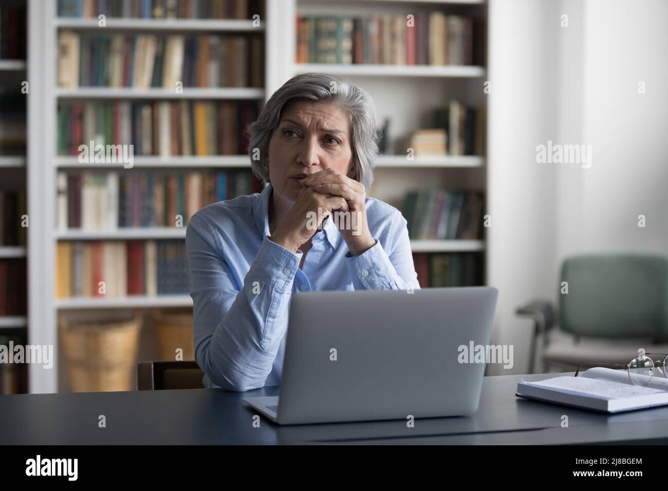 Femme d'affaires pensive et mûre inquiet utilisant un ordinateur portable Banque D'Images