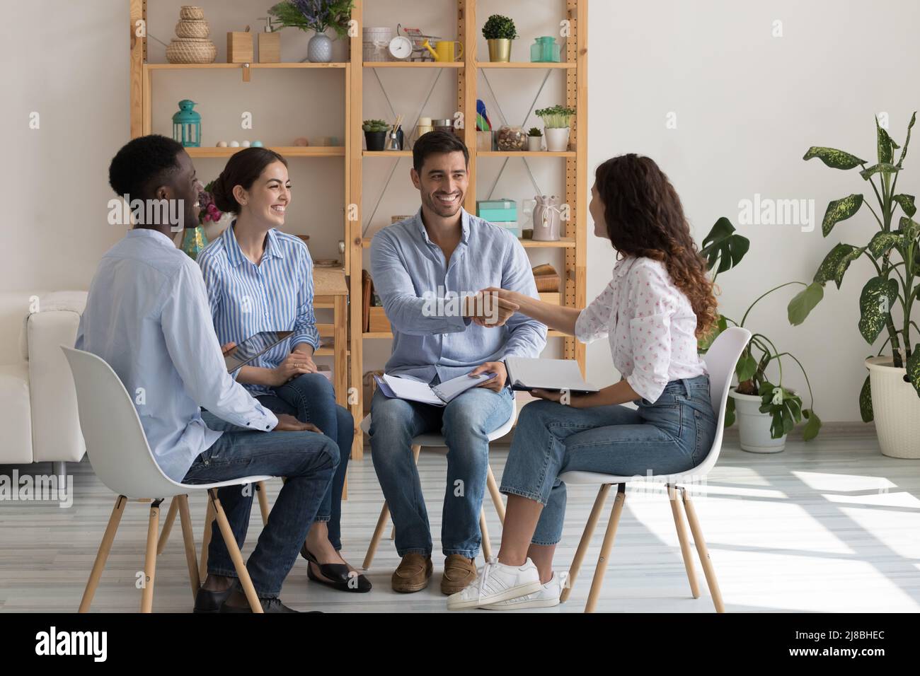 Des employés d'une équipe d'entreprise diversifiée heureux qui se brandient à une réunion d'entreprise Banque D'Images