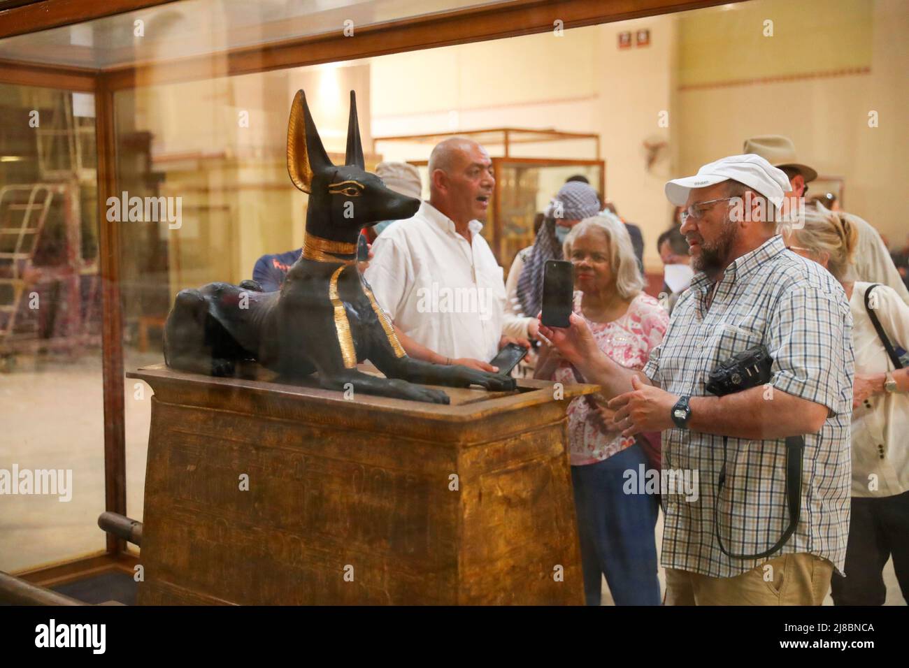 (220515) -- LE CAIRE, le 15 mai 2022 (Xinhua) -- les touristes voient la statue de dieu Anubis découverte au tombeau du roi Toutankhamon, au Musée égyptien du Caire, en Égypte, le 14 mai 2022. En tant que divinité funéraire, Anubis est associé à la momification, aux rituels funéraires et au cimetière dans le mythe égyptien antique, habituellement dépeint comme un canin noir, ou un homme à la tête canine. On peut le trouver dans de nombreuses antiquités pharaoniques au musée égyptien de renommée mondiale. (Xinhua/sui Xiankai) Banque D'Images