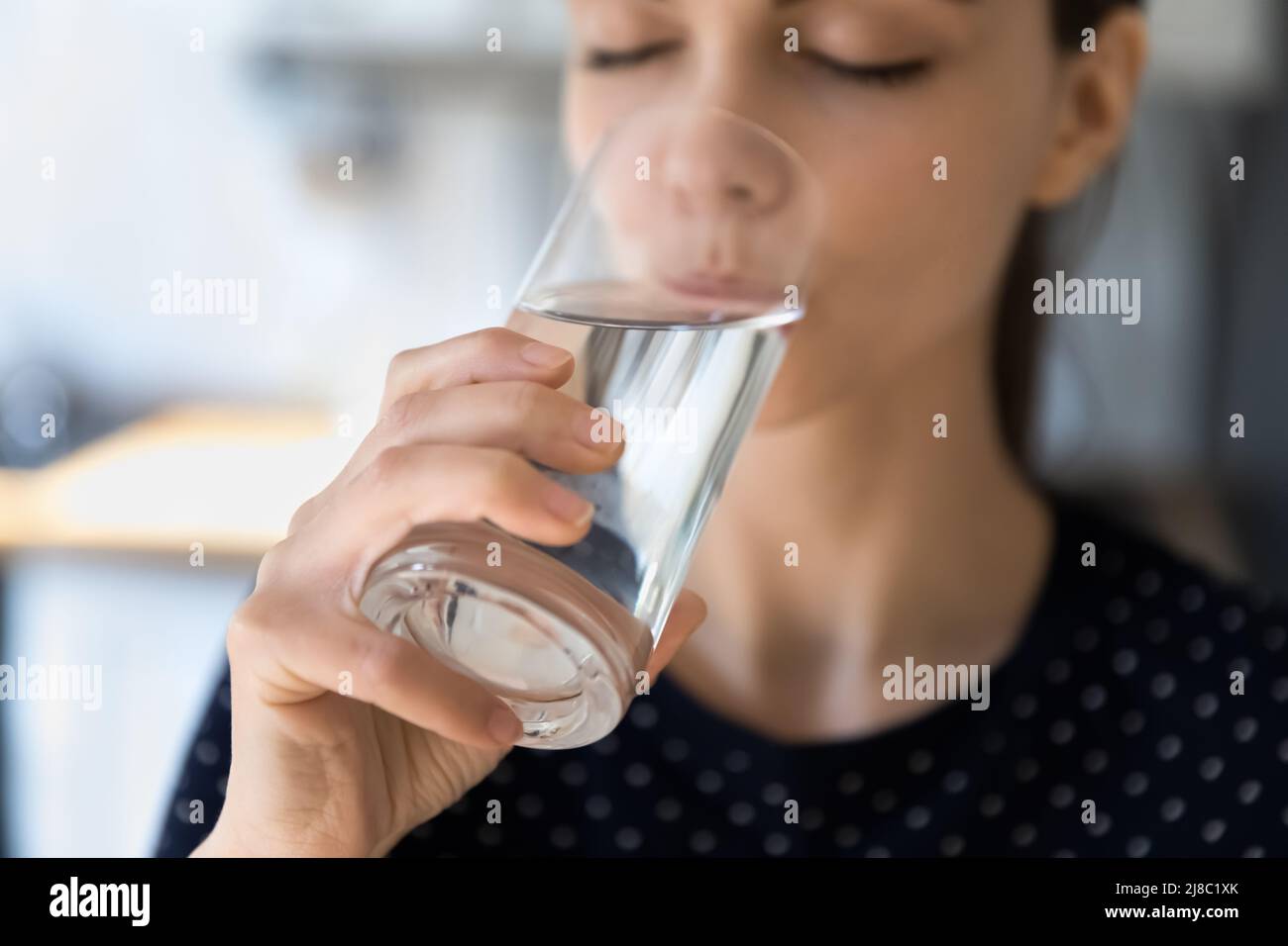 Femme paisible aux yeux fermés, buvant de l'eau propre et filtrée Banque D'Images