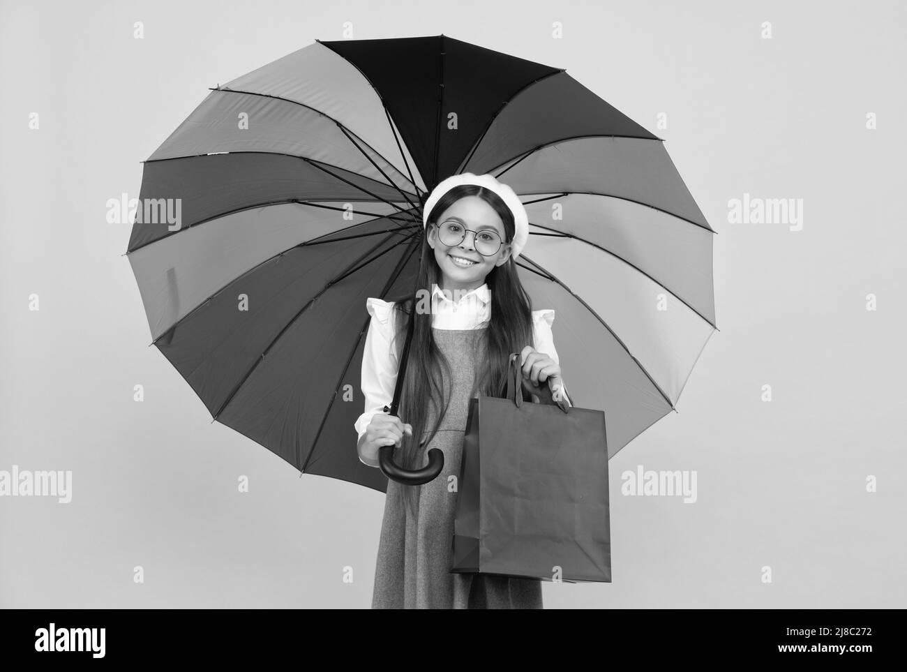 bonne fille de l'adolescence sous parapluie coloré en automne saison tenir sac de shopping, soldes d'automne. Banque D'Images
