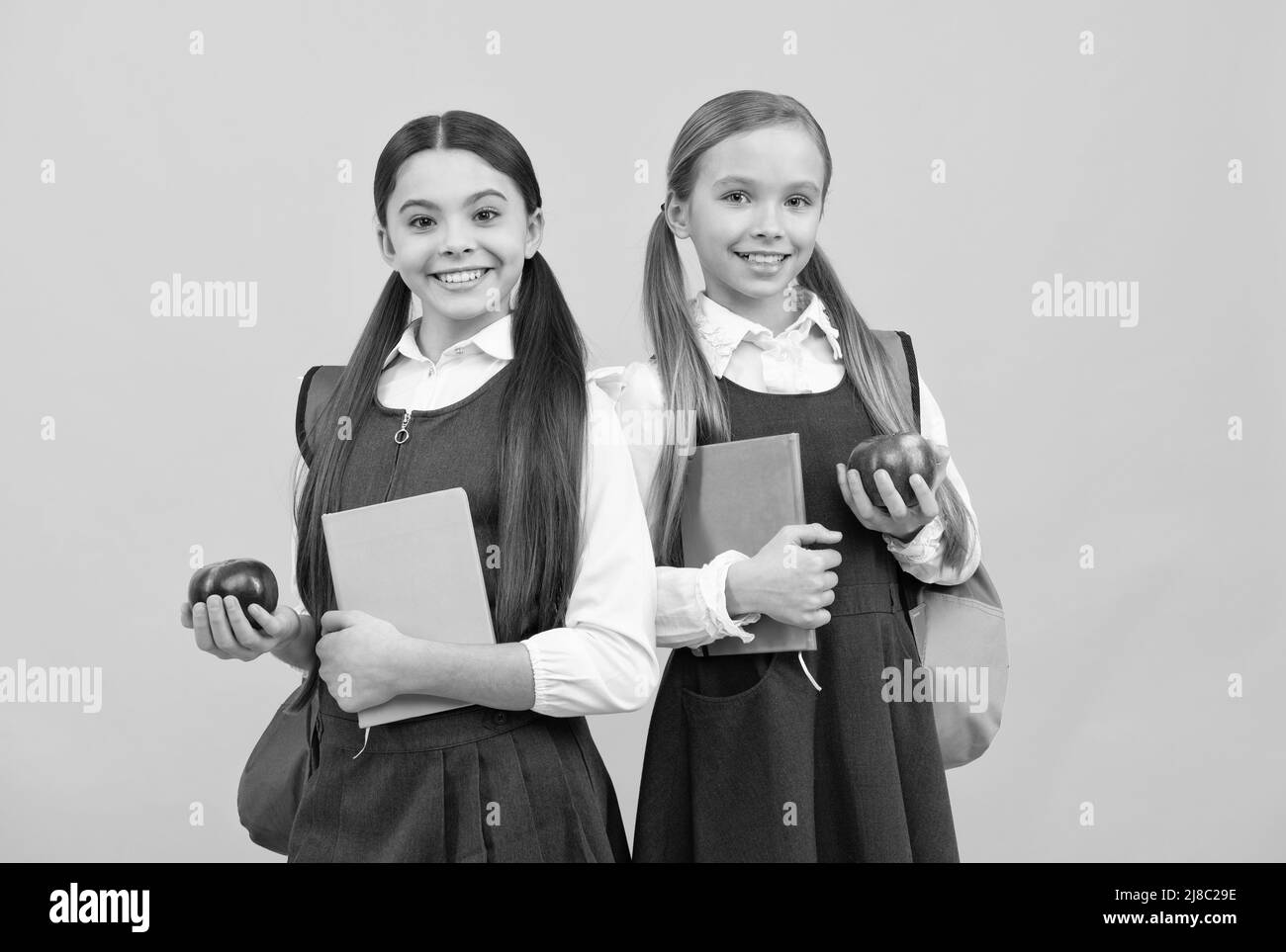 Développer les connaissances sur une alimentation saine. Les enfants tiennent des livres et des pommes. Alimentation nutritive à l'école Banque D'Images