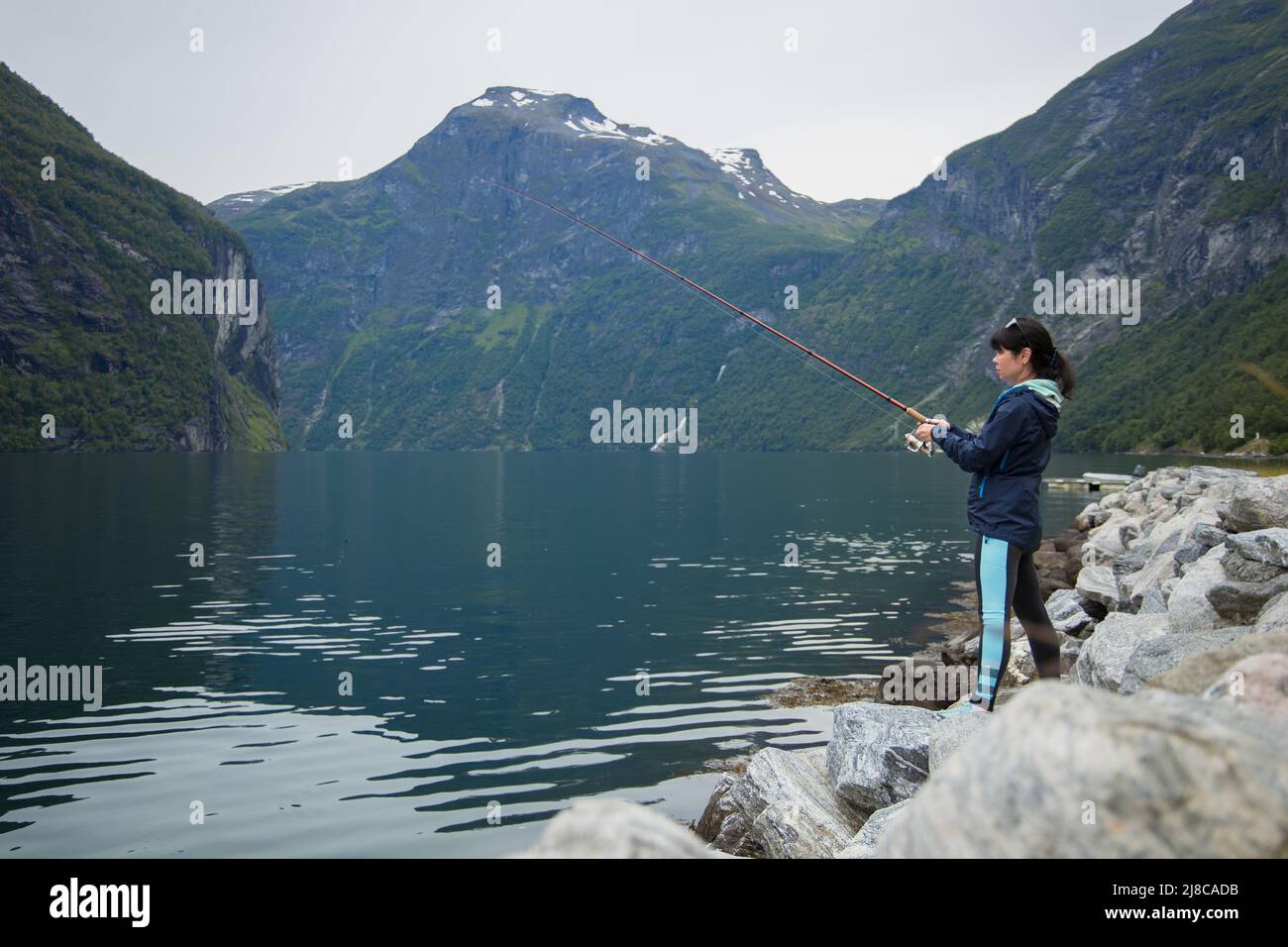 Pêche à la femme sur la canne à pêche spinning en Norvège. La pêche en Norvège est une façon d'embrasser le mode de vie local. D'innombrables lacs et rivières et d'une ampleur Banque D'Images