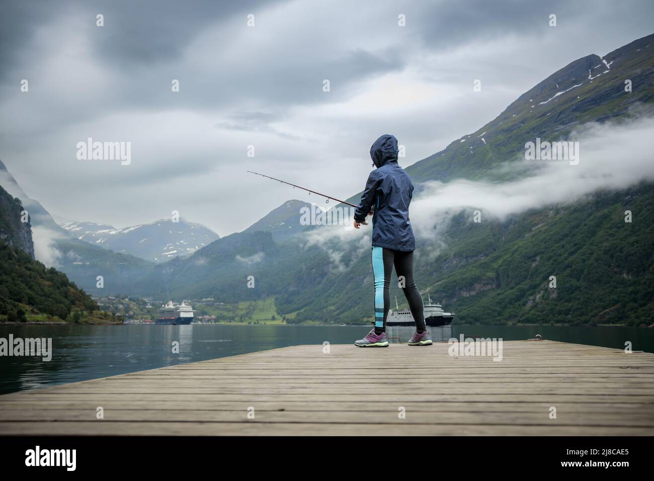 Pêche à la femme sur la canne à pêche spinning en Norvège. La pêche en Norvège est une façon d'embrasser le mode de vie local. D'innombrables lacs et rivières et d'une ampleur Banque D'Images