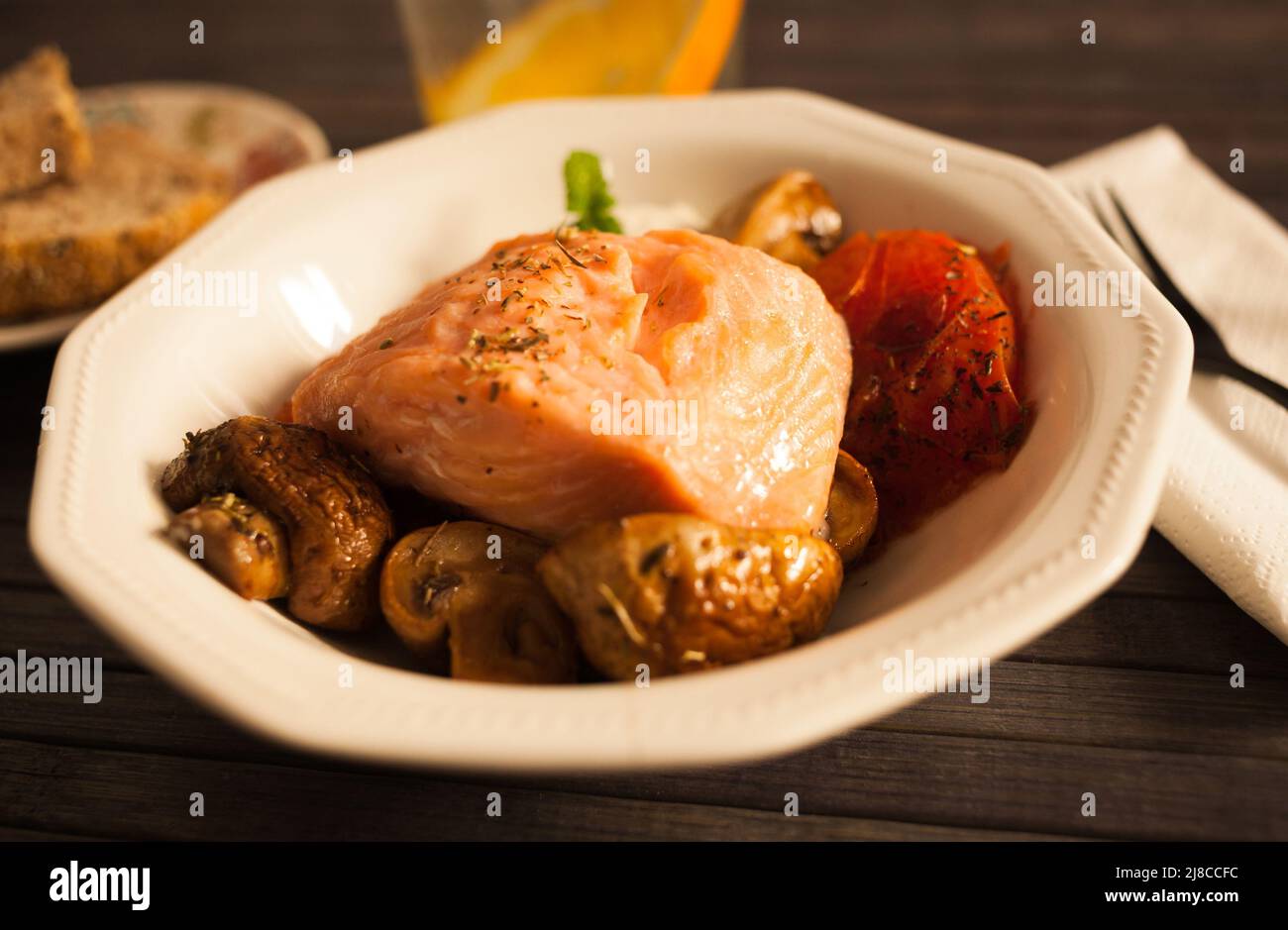 faire mijoter une tranche de saumon avec du spinon de tomate et de la sauce à la noix de coco dans un bol blanc Banque D'Images