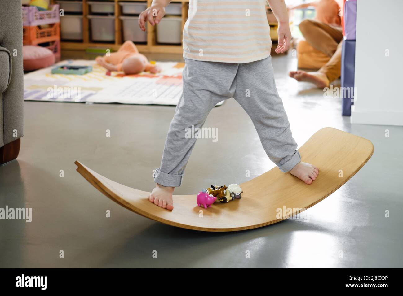 Enfant jouant sur le tableau d'équilibre pour les tout-petits dans la chambre des enfants. Panneau de bas de caisse courbe utilisé pour le développement physique des moteurs à la maison. Garçon jouant, se mettre en forme avec Banque D'Images