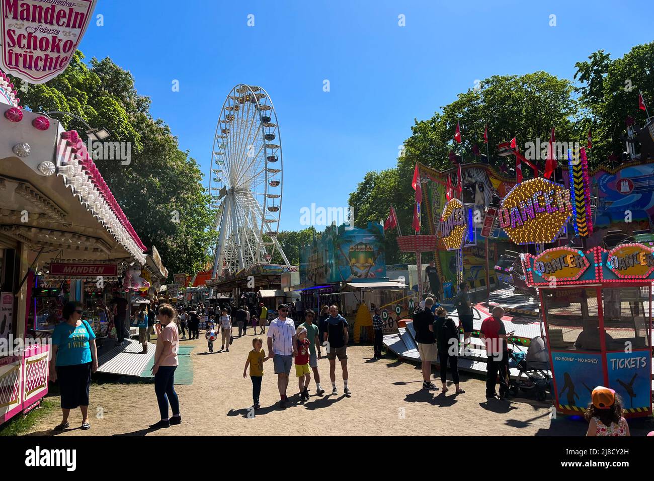 BERLIN, ALLEMAGNE - 15 MAI 2022 : Foire de divertissement surpeuplée, Carnaval Neuköllner Maientage avec DANSEUSE de carnaval, Ferris Wheel Riesenrad et concession stan Banque D'Images