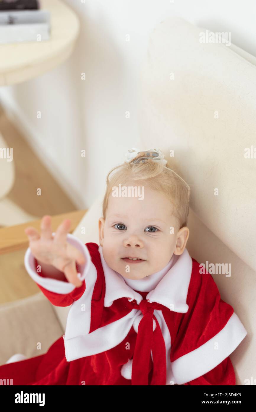 Enfant fille vêtue de la robe de noël avec implants cochléaires s'amuser à la maison - aide auditive et technologies innovantes pour le traitement de la surdité Banque D'Images