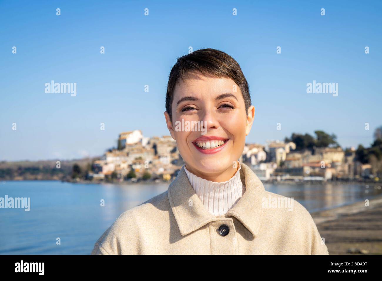 Belle femme voyageant à Anguillara Sabazia, un beau village italien. Une femme aux cheveux courts sourit et regarde dans l'appareil photo. Copier l'espace Banque D'Images