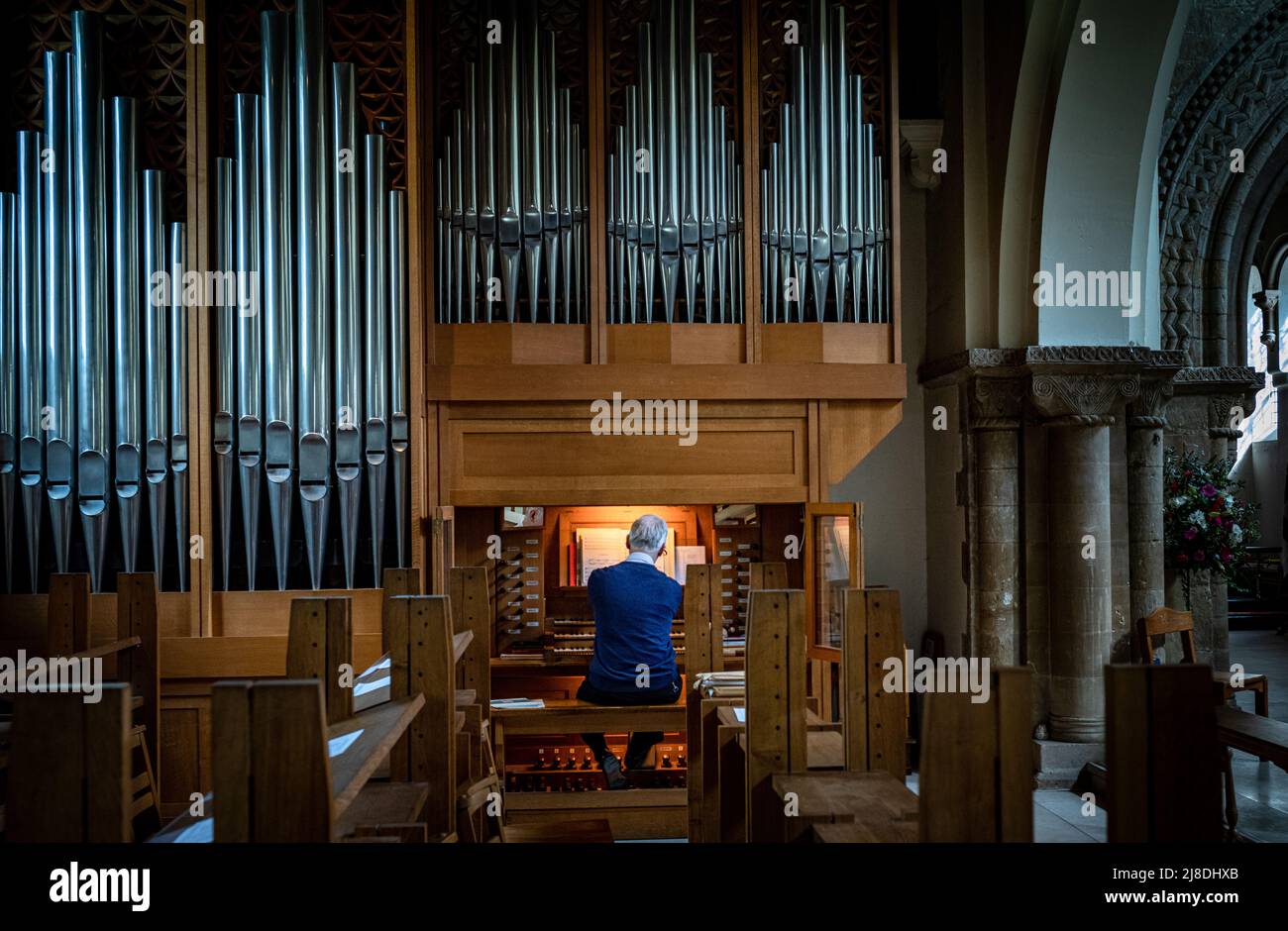 Un organiste joue seul dans l'église vide St Pierre de Petersfield, Hampshire, Angleterre Banque D'Images