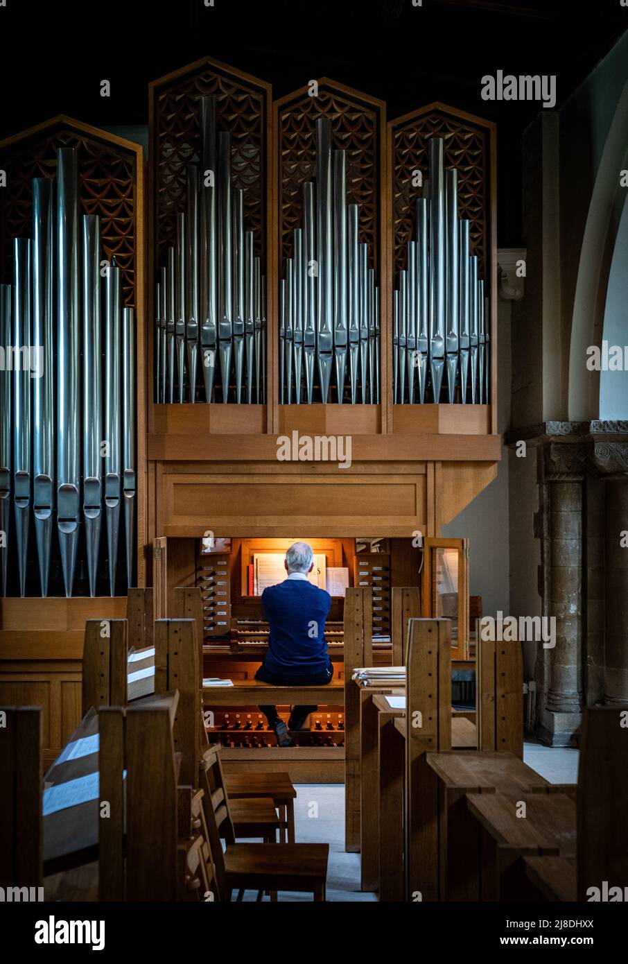 Un organiste joue seul dans l'église vide St Pierre de Petersfield, Hampshire, Angleterre Banque D'Images
