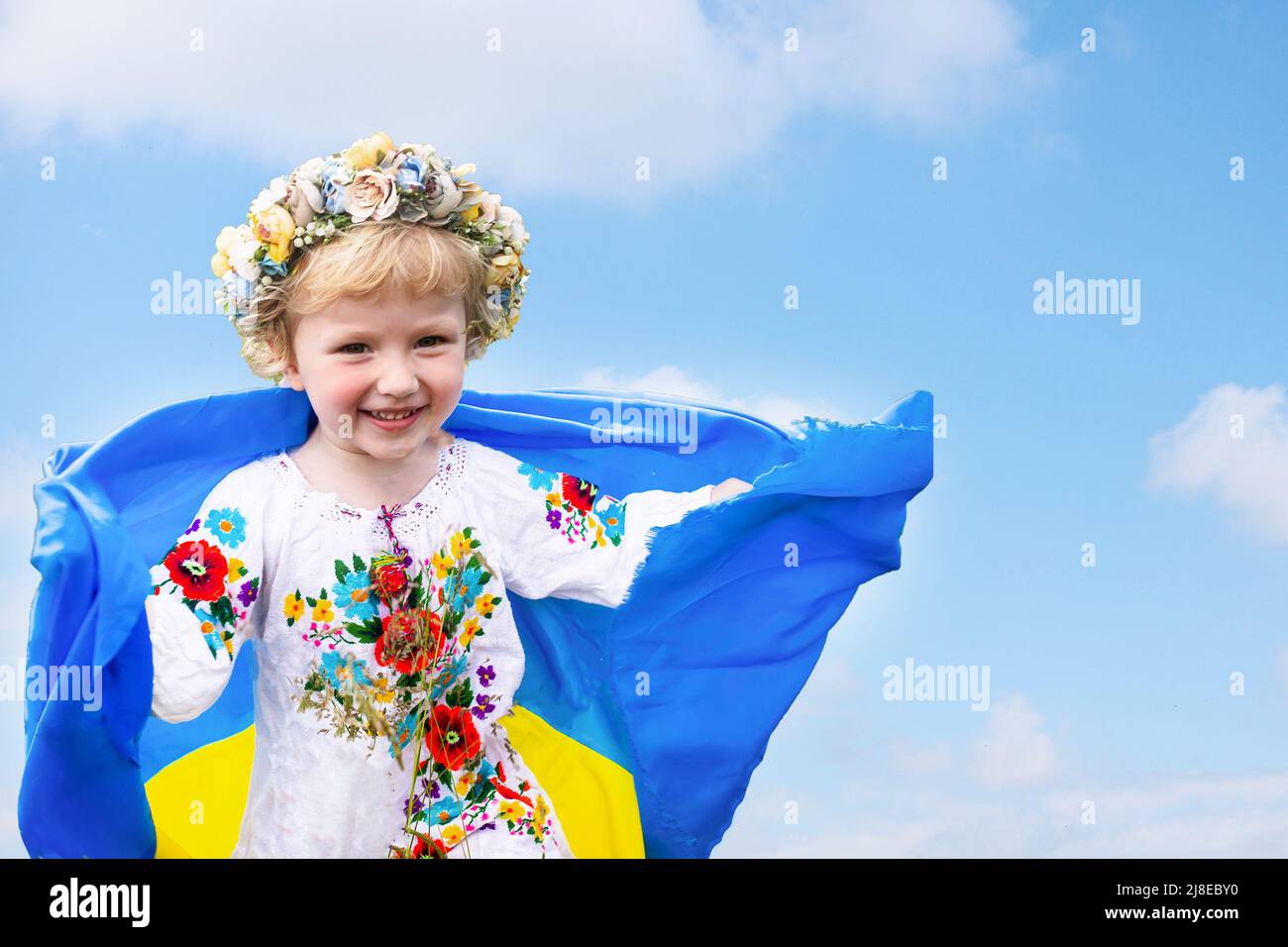 Drapeau ukrainien bleu jaune dans les mains d'une fille qui court sur le champ de blé de la mangled. Enfant heureux avec le drapeau de l'Ukraine. Jour de l'indépendance. Marquer le jour. Const Banque D'Images