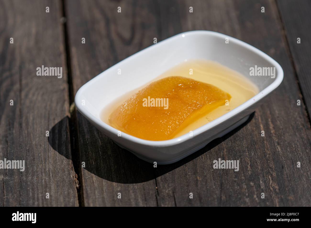 Mise au point sélective vers le bas de la plaque de confiture de coing sur une table en bois. Banque D'Images