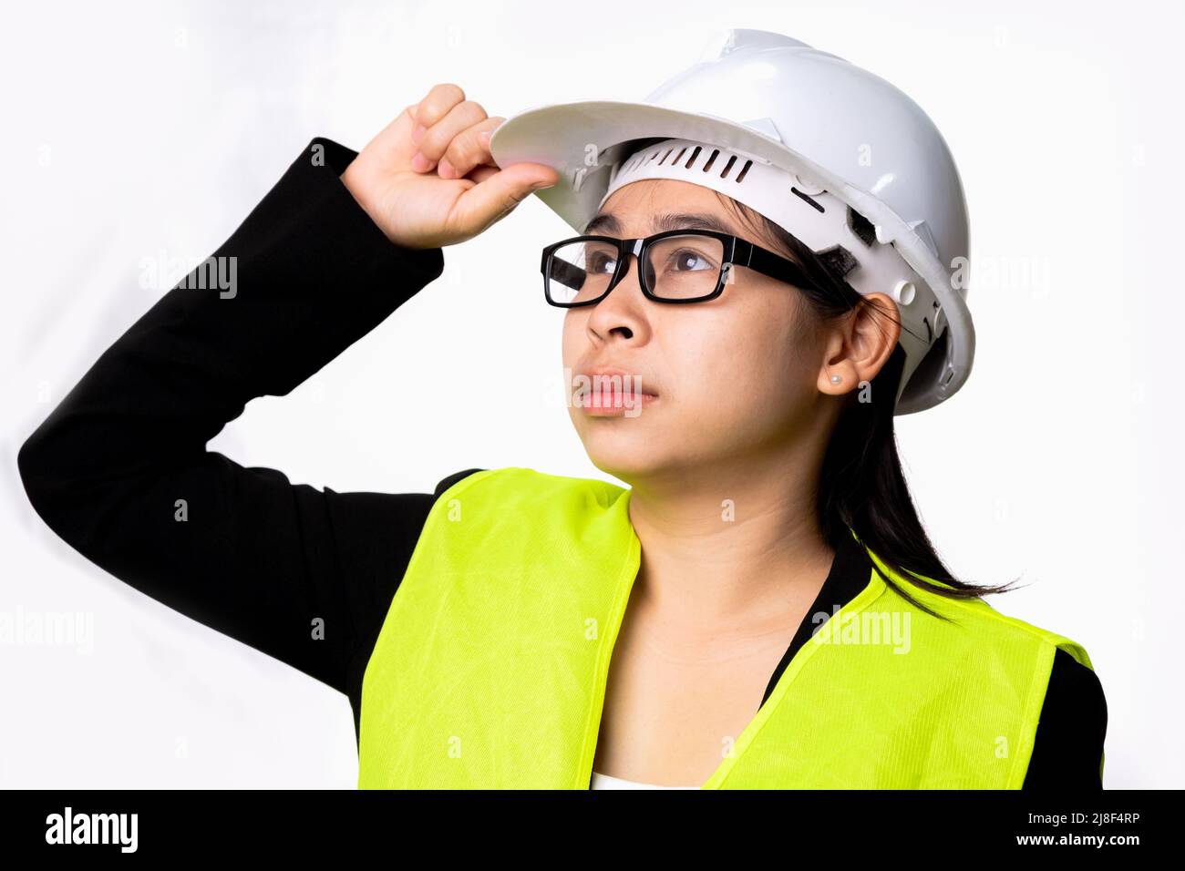 Femme ingénieure confiante portant un casque et regardant la distance isolée sur fond blanc en studio. Banque D'Images