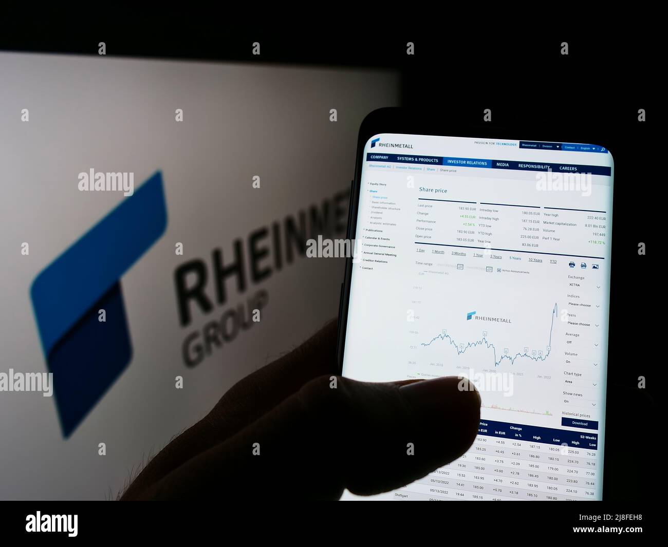 Personne tenant un téléphone portable avec le site Internet de la société allemande de défense Rheinmetall AG à l'écran devant le logo. Concentrez-vous sur le centre de l'écran du téléphone. Banque D'Images