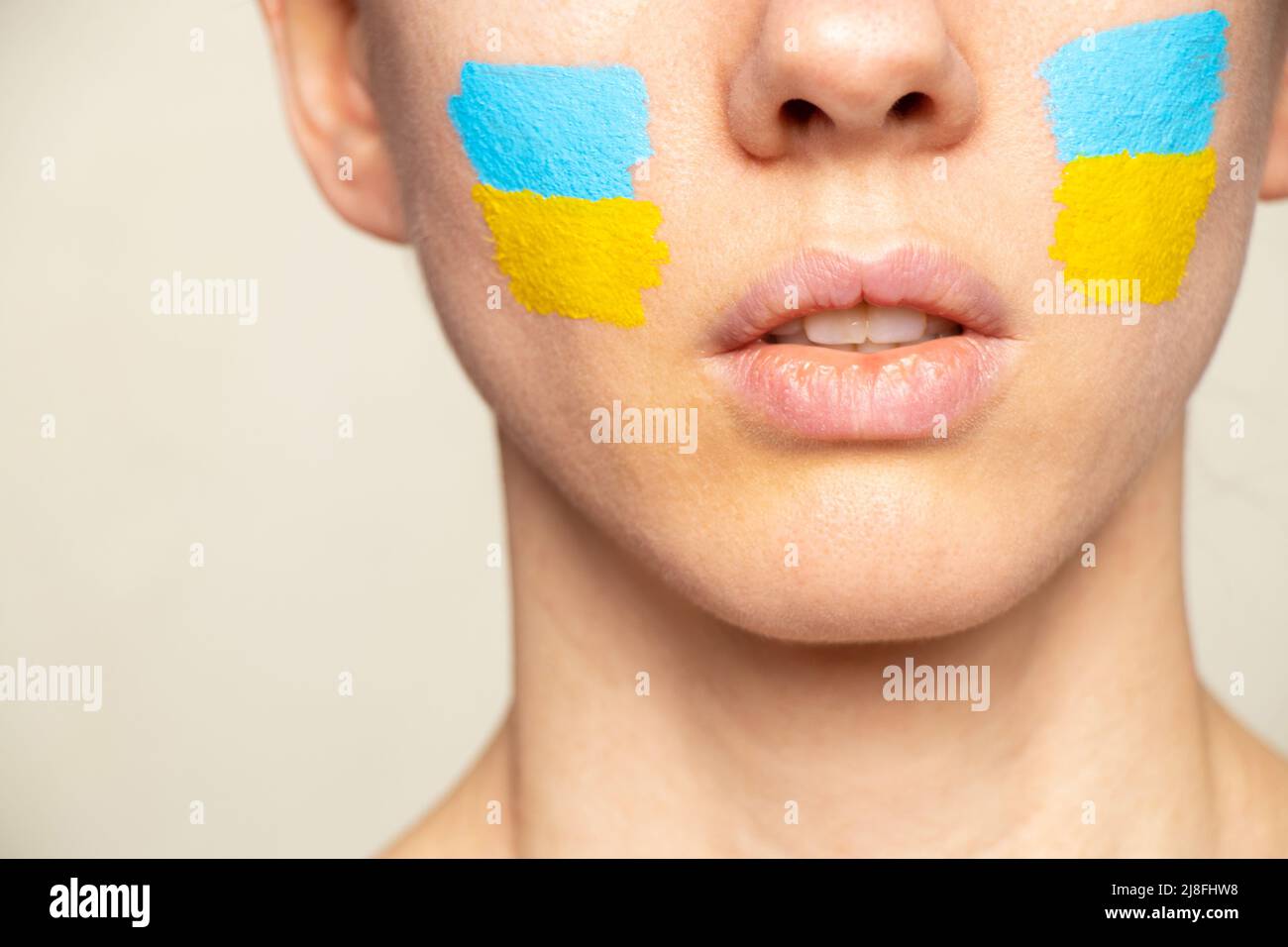 Le visage d'une fille avec le drapeau national de l'Ukraine jaune-bleu sur son visage, patriote, la paix en Ukraine, la loi martiale Banque D'Images