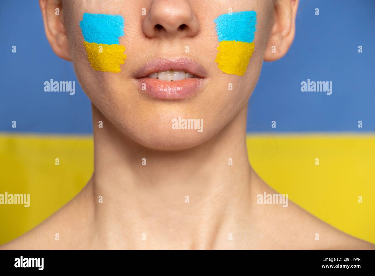Le visage d'une fille avec le drapeau national de l'Ukraine jaune-bleu sur son visage, patriote, la paix en Ukraine, la loi martiale Banque D'Images