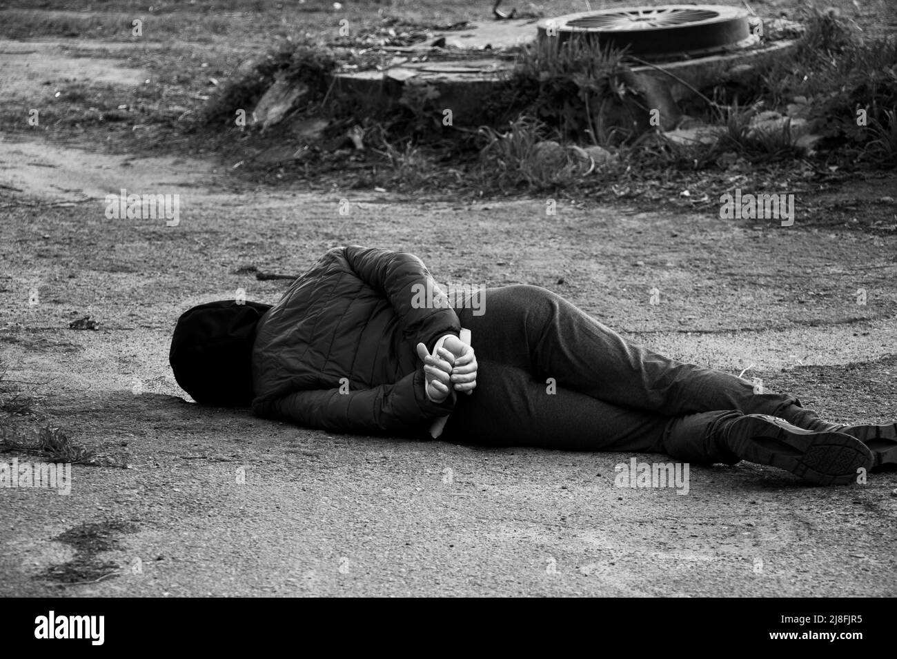 Une femme ukrainienne morte se trouve dans la rue avec ses mains attachées avec une corde blanche et a été tuée dans le dos en Ukraine, une manifestation de mort dans la ville de Banque D'Images