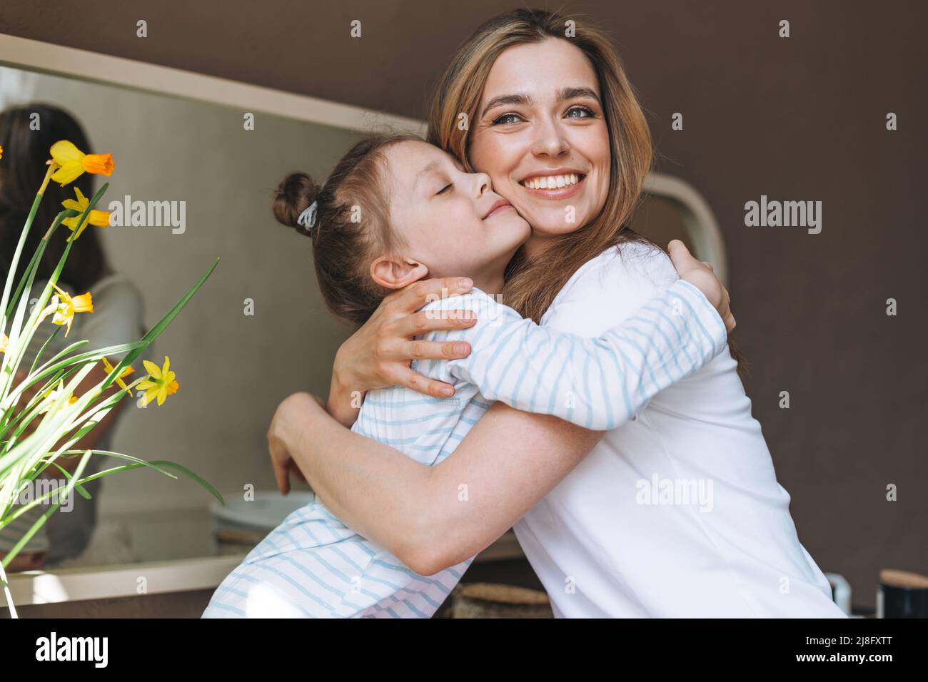 Jeune mère femme avec de longs cheveux avec petite fille Tween fille en pyjama s'amusant le matin à la maison Banque D'Images