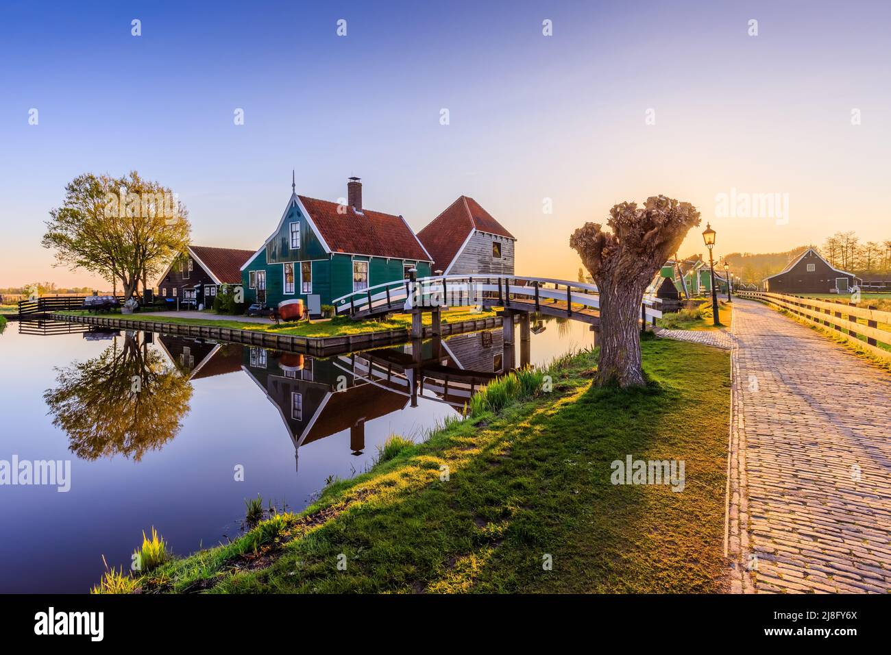 Village de Zaanse Schans, pays-Bas. Moulin à vent hollandais et maison traditionnelle au lever du soleil. Banque D'Images