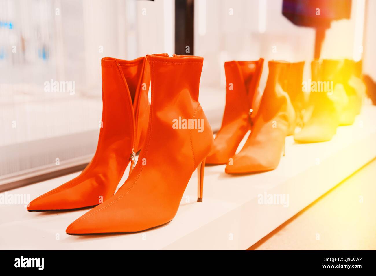 bottes de cheville en daim de femme de chamois rouge sur l'étagère dans le magasin de magasin. bottes en velours. Magasin du centre commercial. Vente au détail Banque D'Images