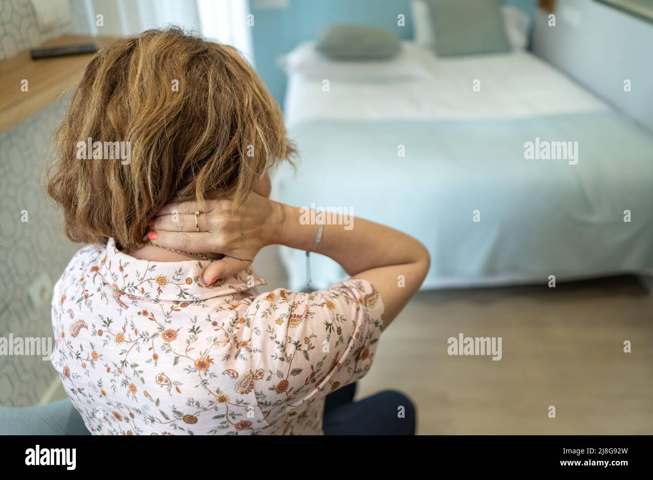 Femme souffrant de douleurs au dos et au cou, frottant la douleur avec sa main. Banque D'Images