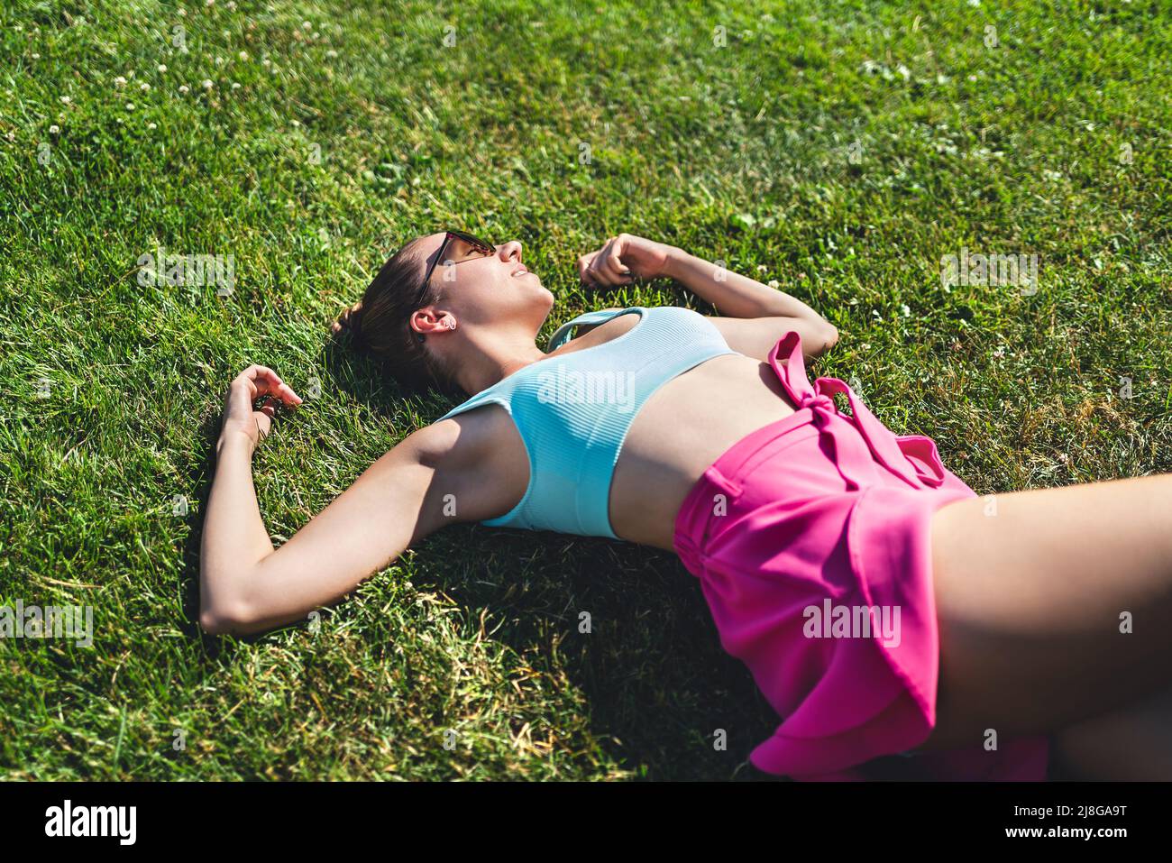 Couché dans l'herbe jour rêvant en été. Femme se sentant bonne, optimiste. Sain magnifique joli modèle relaxant. Ambiance insouciante. Repos paisible. Banque D'Images