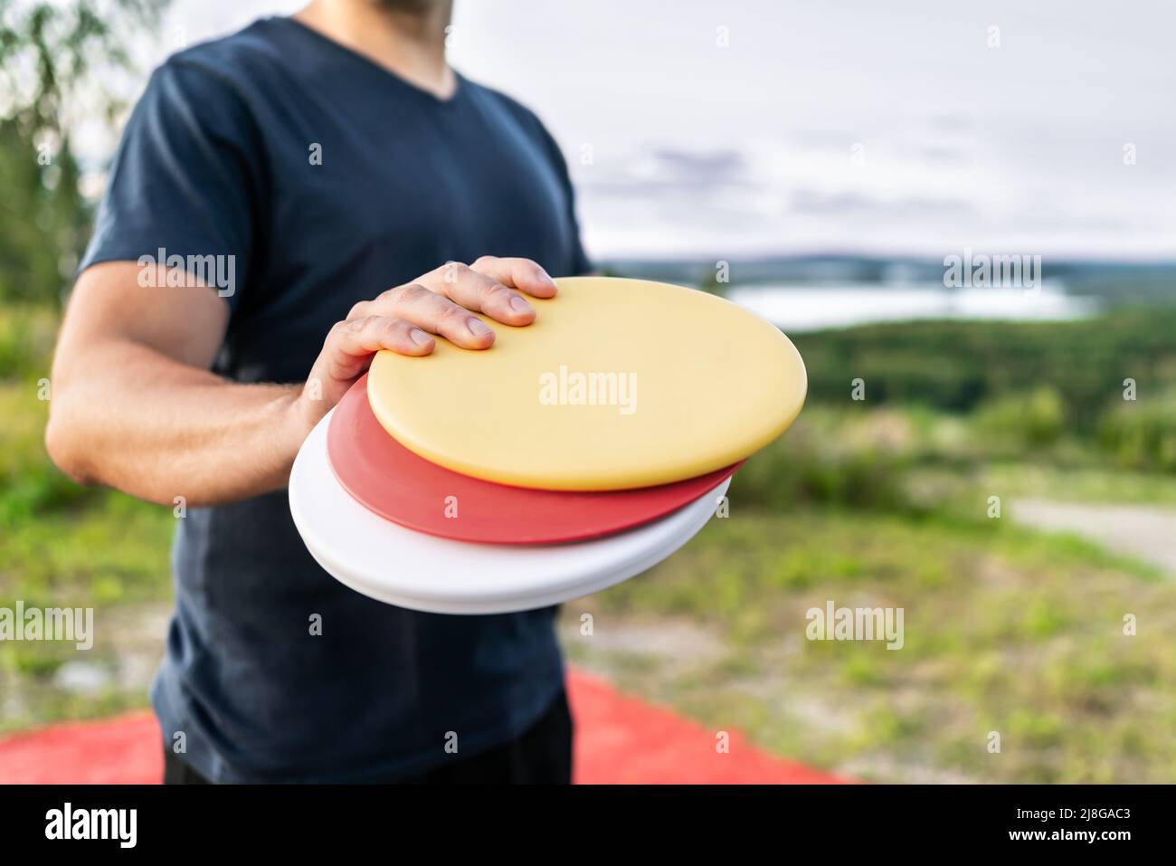Disque de golf avec équipement Frisbee dans le parc. Homme jouant au discgolf. Tournoi de sport de plein air. Paysage d'été en Finlande. Banque D'Images