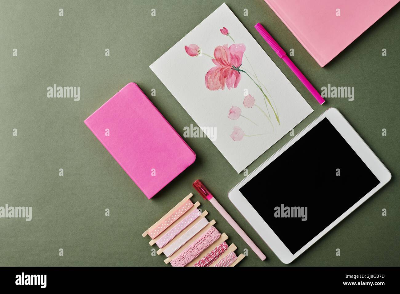 Fait partie de l'espace de travail de designer moderne avec dessin aquarelle de fleur, deux carnets roses, surligneur, stylo et tablette numérique Banque D'Images