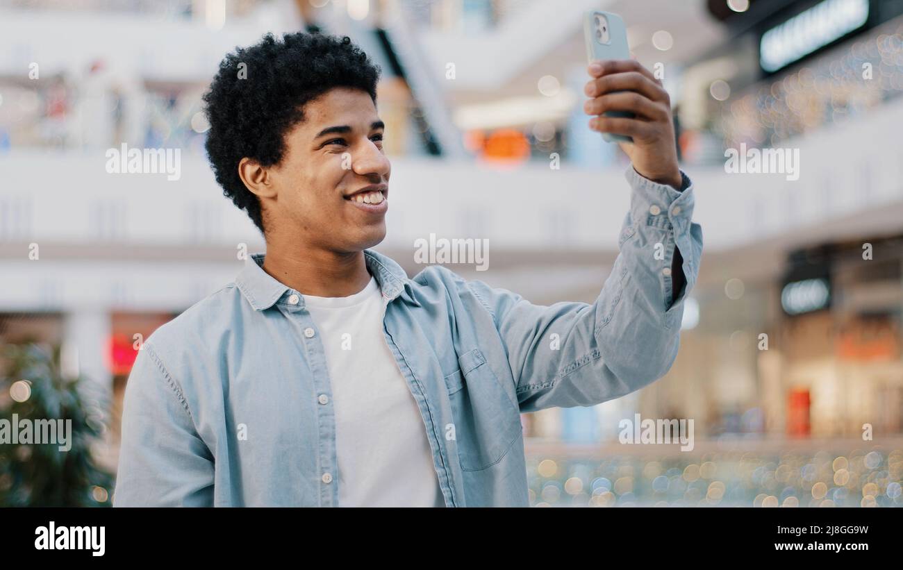 Portrait afro-américain homme étudiant homme à l'intérieur à l'aide d'application mobile téléphone en oring hello parler vidéo appel conférence chat amis à distance Banque D'Images