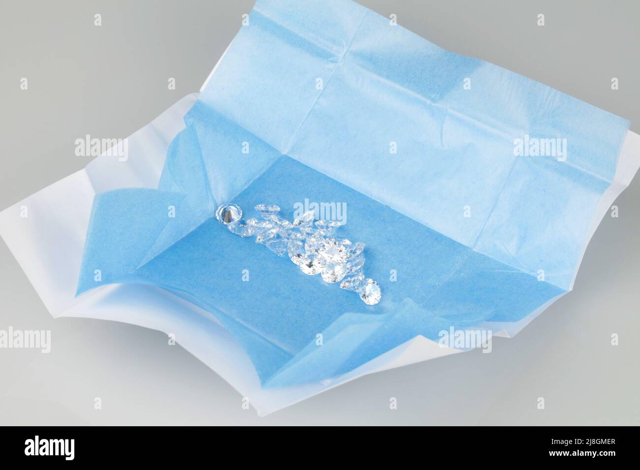 Ouvrez le colis de diamants en vrac avec fond de papier mouchoir bleu. Tailles Diamant assorties. Banque D'Images