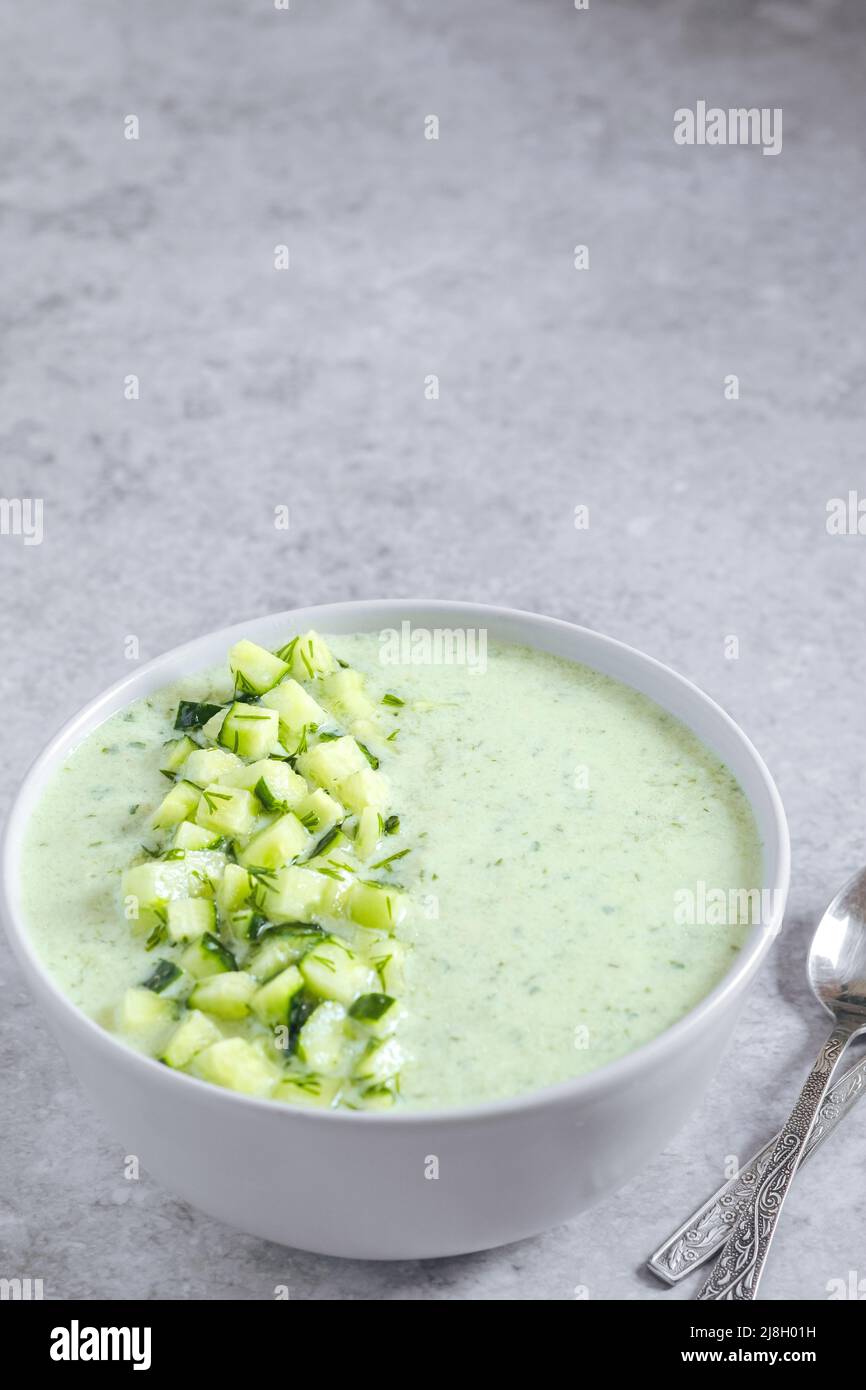 Soupe d'été fraîche et verte au concombre sur fond gris. Espace pour le texte. Concept d'alimentation saine Banque D'Images