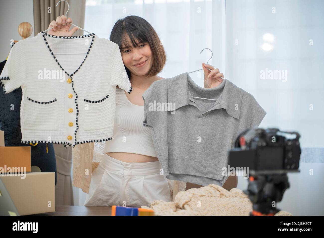 Jeune femme travaillant en direct streaming magasin de vêtements en ligne à la maison. Banque D'Images