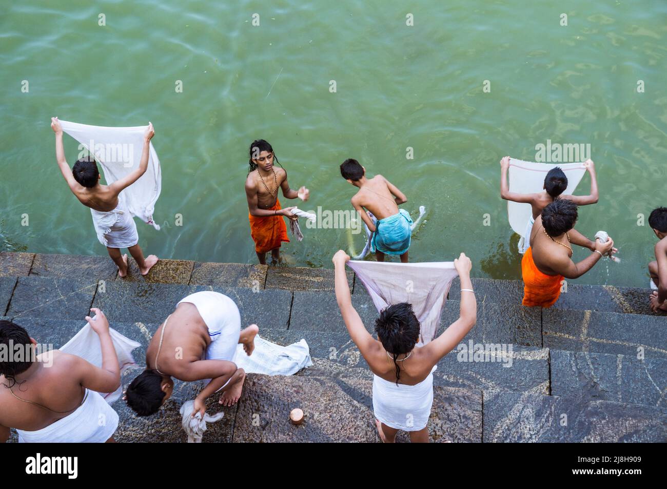 Udupi, Karnataka, Inde : les jeunes novices brahmin lavent leurs vêtements au réservoir d'eau Madhva Sarovara adjacent au temple Krishna du 13th siècle.Le Banque D'Images