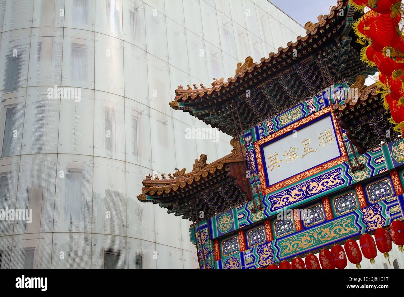 Le Chinatown Gate dans le style de la dynastie Qing le Grand chemin d'entrée à Chinatown, Londres UK contrastant avec le moderne Glass fronted W London Hotel Banque D'Images