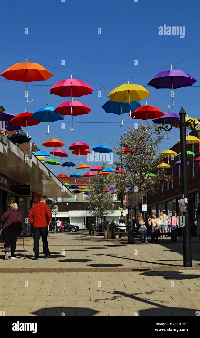Une exposition colorée de parasols a été installée sur une voie piétonne dans le centre d'Alfreton, dans le Derbyshire. Banque D'Images