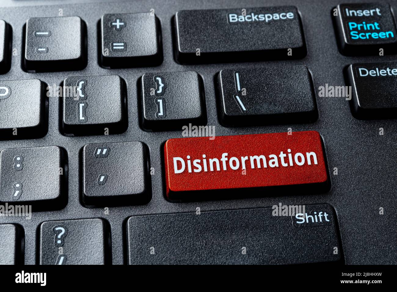 Affiche la touche rouge de désinformation sur le clavier noir du bureau. Message d'avertissement sur la touche entrée de l'ordinateur. Propagande, manipulation et censure dans les médias Banque D'Images