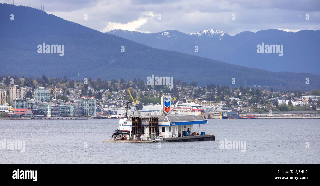 Station-service Chevron à Coal Harbour avec sites urbains et industriels en arrière-plan. Banque D'Images